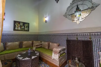 a living room with a couch and a table at Riad Sanaa Rose in Fès