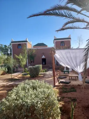 a hammock in front of a house at Riad ma bonne étoile in Kasr Bounou