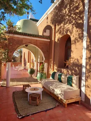 an outdoor patio with a couch and a table at Riad ma bonne étoile in Kasr Bounou