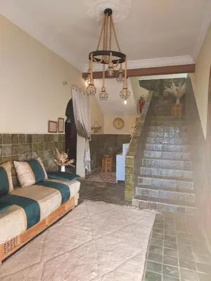 a bedroom with two beds and a staircase at Riad ma bonne étoile in Kasr Bounou