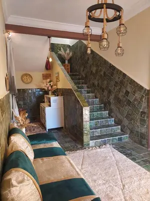 a living room with a staircase with green tiles at Riad ma bonne étoile in Kasr Bounou