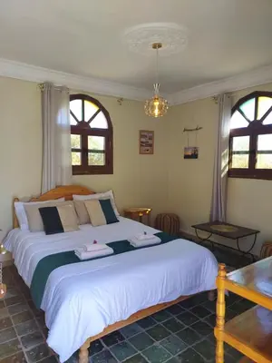 a bedroom with a large bed with two towels on it at Riad ma bonne étoile in Kasr Bounou