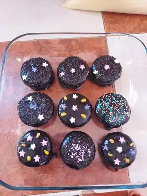 a glass tray of chocolate cupcakes with sprinkles at Riad ma bonne étoile in Kasr Bounou