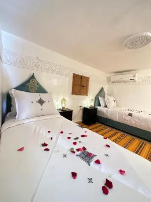a bedroom with a bed with red roses on it at Dar Khmissa Fes-Luxury Stay Fes Medina in Fès
