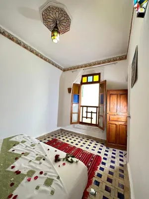 a bedroom with a bed and a window at Dar Khmissa Fes-Luxury Stay Fes Medina in Fès