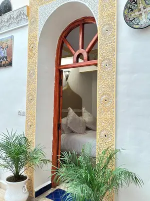 a mirror in a room with a bed in it at Dar Khmissa Fes-Luxury Stay Fes Medina in Fès