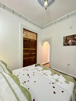 a bedroom with a bed with flowers on it at Dar Khmissa Fes-Luxury Stay Fes Medina in Fès