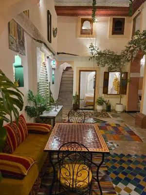 a living room with a couch and a table at Dar Khmissa Fes-Luxury Stay Fes Medina in Fès