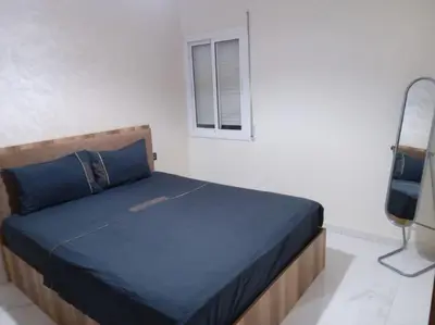 a bed in a white room with a window at Appart prestigieux+T bien équipé in Fès