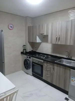 a kitchen with a stove and a sink and a dishwasher at Appart prestigieux+T bien équipé in Fès