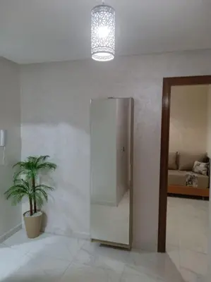 a room with a potted plant and a mirror at Appart prestigieux+T bien équipé in Fès