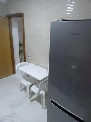 a kitchen with a table and a refrigerator at Appart prestigieux+T bien équipé in Fès