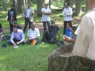 a group of people standing and sitting in the grass at Riad Azrou in Azrou