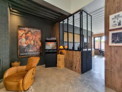 a living room with a movie poster on the wall at Villa avec gouvernante et 2 piscines dont une chauffée dans domaine securise in Marrakech