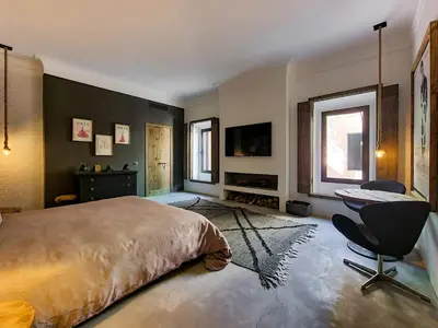 a bedroom with a bed and a desk and a window at Villa avec gouvernante et 2 piscines dont une chauffée dans domaine securise in Marrakech