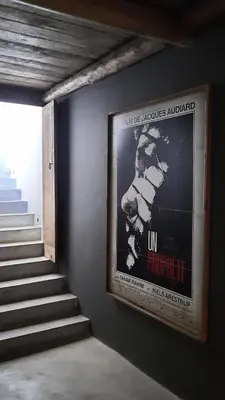a movie poster on a wall next to a staircase at Villa avec gouvernante et 2 piscines dont une chauffée dans domaine securise in Marrakech