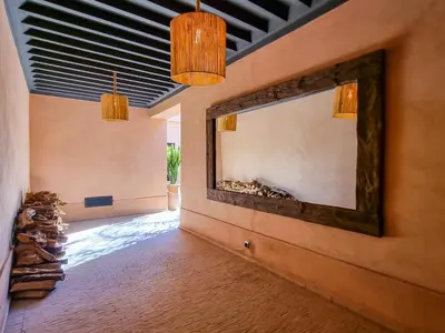 a living room with a large mirror on the wall at Villa avec gouvernante et 2 piscines dont une chauffée dans domaine securise in Marrakech