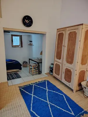 a living room with a blue rug and a table at La Maison des Amis in Fès