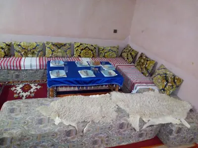 a living room with a table and a couch at ECOLODGE MISS ROSE CHEZ LA FAMILLE in Boumalne