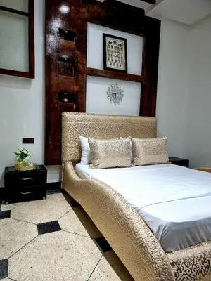 a bedroom with a large bed with white sheets at Fassia in Fès
