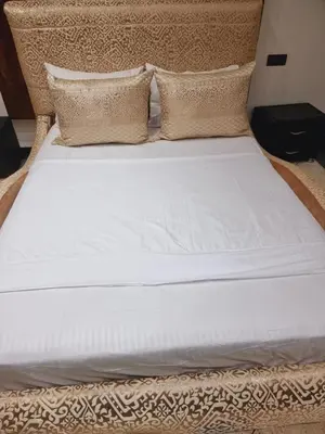 a bed with white sheets and pillows on it at Fassia in Fès