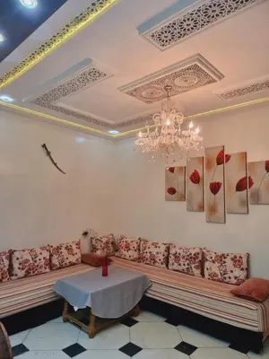 a living room with a couch and a chandelier at Fassia in Fès