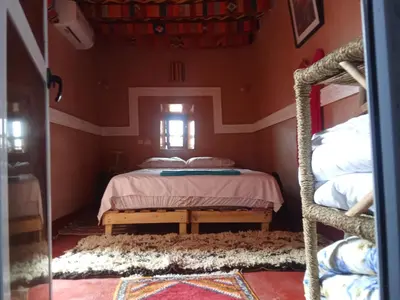 a bedroom with two bunk beds and a window at Maison d'hôtes tilleli in Tamnougalt