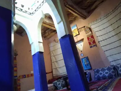 a room with blue columns in a room with a couch at Maison d'hôtes tilleli in Tamnougalt