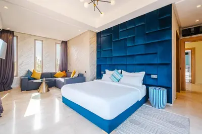 a bedroom with a large bed and a blue wall at Dar ilyan in Marrakech