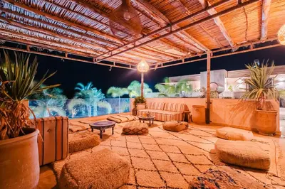 a large patio with a couch and tables and plants at Dar ilyan in Marrakech