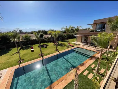 a swimming pool in a yard with palm trees at Dar ilyan in Marrakech