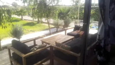 a porch with a couch and a table and a window at Ferme Marsa in Guercif