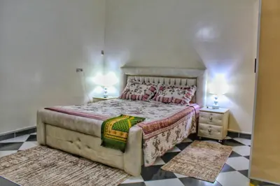 a bedroom with a bed and a checkerboard floor at Yassers Residence in Er Rachidia