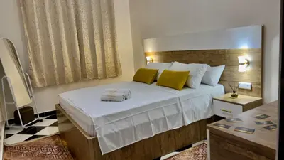 a bedroom with a large bed with yellow pillows at Yassers Residence in Er Rachidia