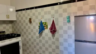 a kitchen with flags hanging on a tiled wall at Yassers Residence in Er Rachidia