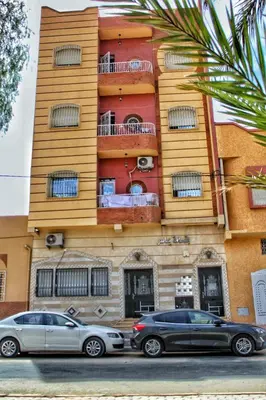 two cars parked in front of a building at Yassers Residence in Er Rachidia