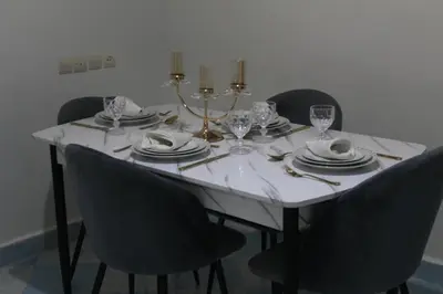 a dining room table with chairs and a white tablecloth at Yassers Residence in Er Rachidia