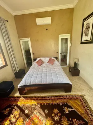 a bedroom with a bed and a rug on the floor at Motia's farm in Marrakech