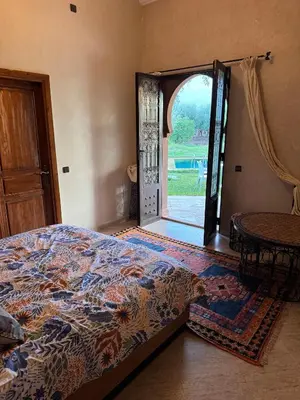 a bedroom with a bed and an open door at Motia's farm in Marrakech