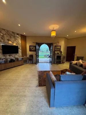 a living room with two couches and a tv at Motia's farm in Marrakech