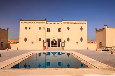 a building with a pool in front of it at Traditional Riad Merzouga Dunes in Merzouga