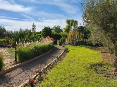 a garden with grass and plants and a path at Dar Lalla Mhalla Villa 975m2 5ch - Rt de Fes in Marrakech