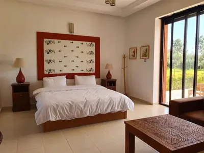 a bedroom with a bed and a large window at Dar Lalla Mhalla Villa 975m2 5ch - Rt de Fes in Marrakech