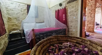 a bedroom with a bed with a mosquito net at Kasbah Dar Talouste in Afela nʼIsly