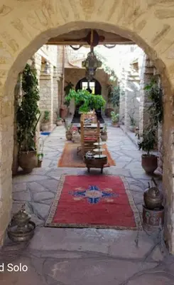 a hallway with an archway with a red rug at Kasbah Dar Talouste in Afela nʼIsly