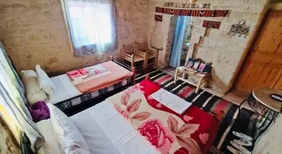 a large room with two beds and a window at Kasbah Dar Talouste in Afela nʼIsly