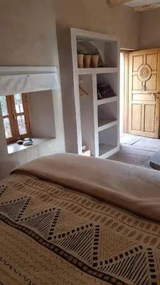 a bedroom with a large bed and a window at Alliance Berbère - Vallée d'Aït Bouguemez in Timit