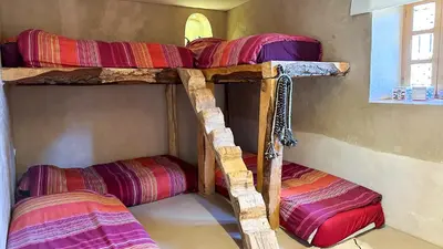 two bunk beds in a room with a window at Alliance Berbère - Vallée d'Aït Bouguemez in Timit