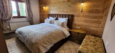 a bedroom with a bed and a wooden wall at Chalets-Appartements Tourtite in Ifrane