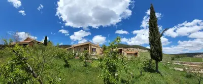a house on a hill in a field with trees at Chalets-Appartements Tourtite in Ifrane